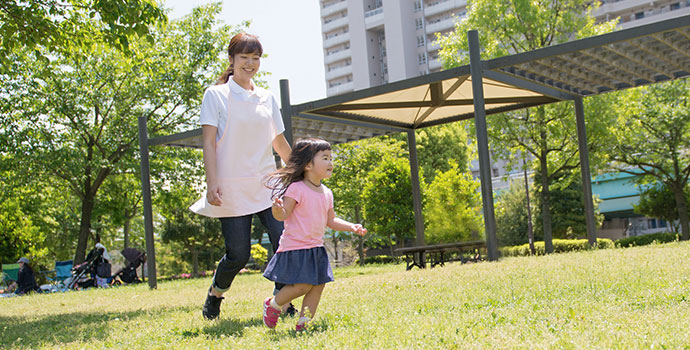 屋外の保育士と子ども