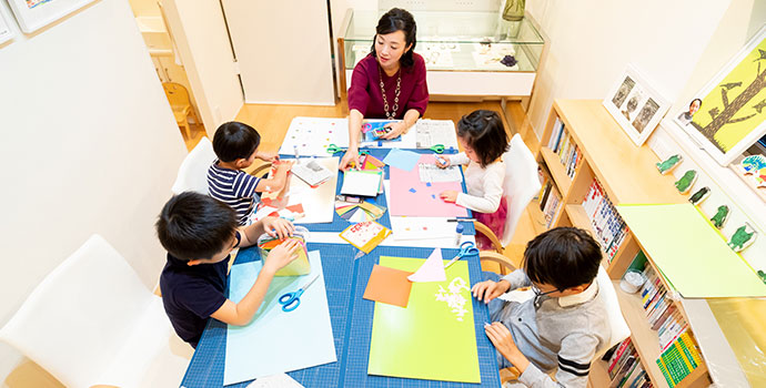 子どもの可能性を広げる幼児教育のため本を子どもに見せる女性（今泉真樹さん）