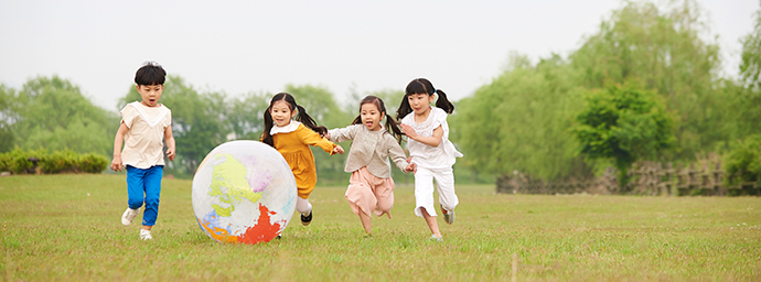 大きなボールを追いかける子供たちの様子を写した写真