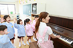 ピアノを弾く女性保育士の写真